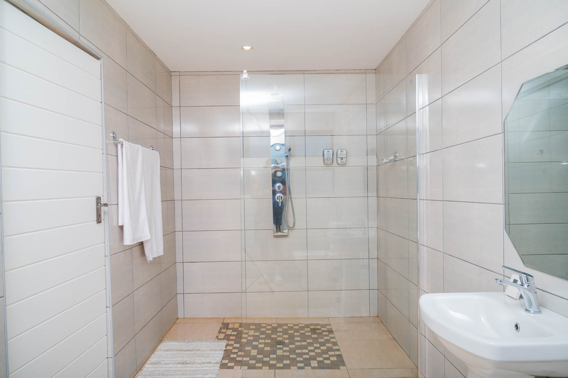 Deluxe Suite bathroom with sleek shower, modern fittings, and bright lighting